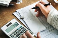 Foto: Person arbeitet am Taschenrechner